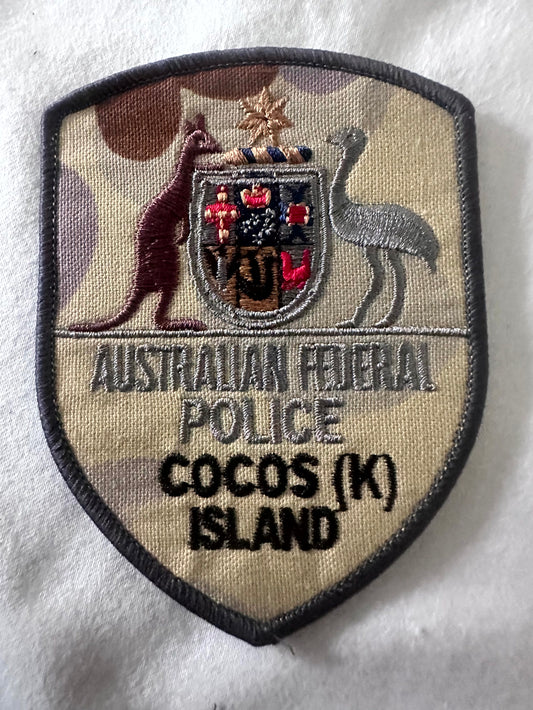 AFP Australian Federal Police Christmas Island AUSCAM camouflage embroidered shield patch – tan/brown/olive camo base, Australian Coat of Arms, AUSTRALIAN FEDERAL POLICE and CHRISTMAS ISLAND text, dark merrow border