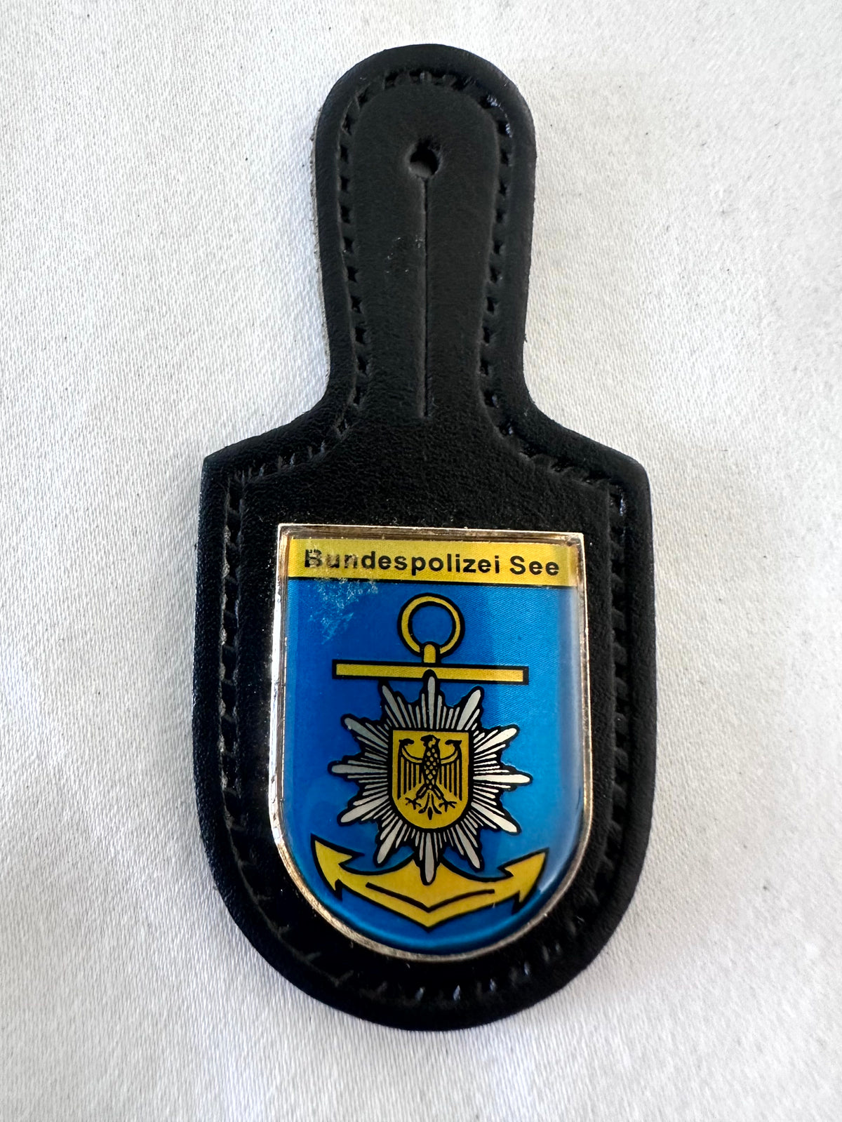 Bundespolizei See federal maritime police black suede T-bar spade pocket badge, vivid blue shield field with large gold ship anchor ring crossbar flukes overlaid with silver white Bundespolizei Polizeistern sunburst star bearing black Bundesadler at centre, gold Bundespolizei See header bar